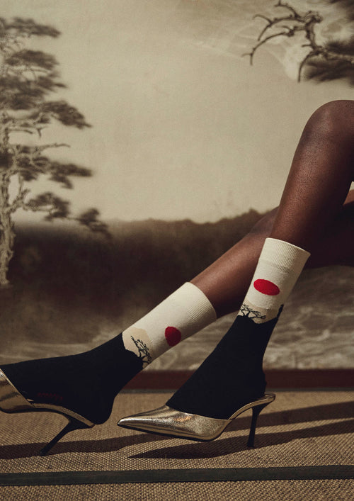 Escena minimalista en tonos beige y negro con un samurái y un sol rojo - BESOCKS. BeJapan Samurai
