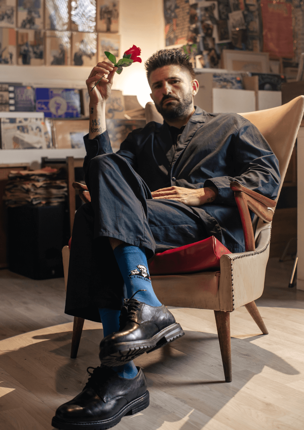 Hombre sentado en un sillón con calcetines personalizables y una rosa en la mano, representando el nuevo branding corporativo.