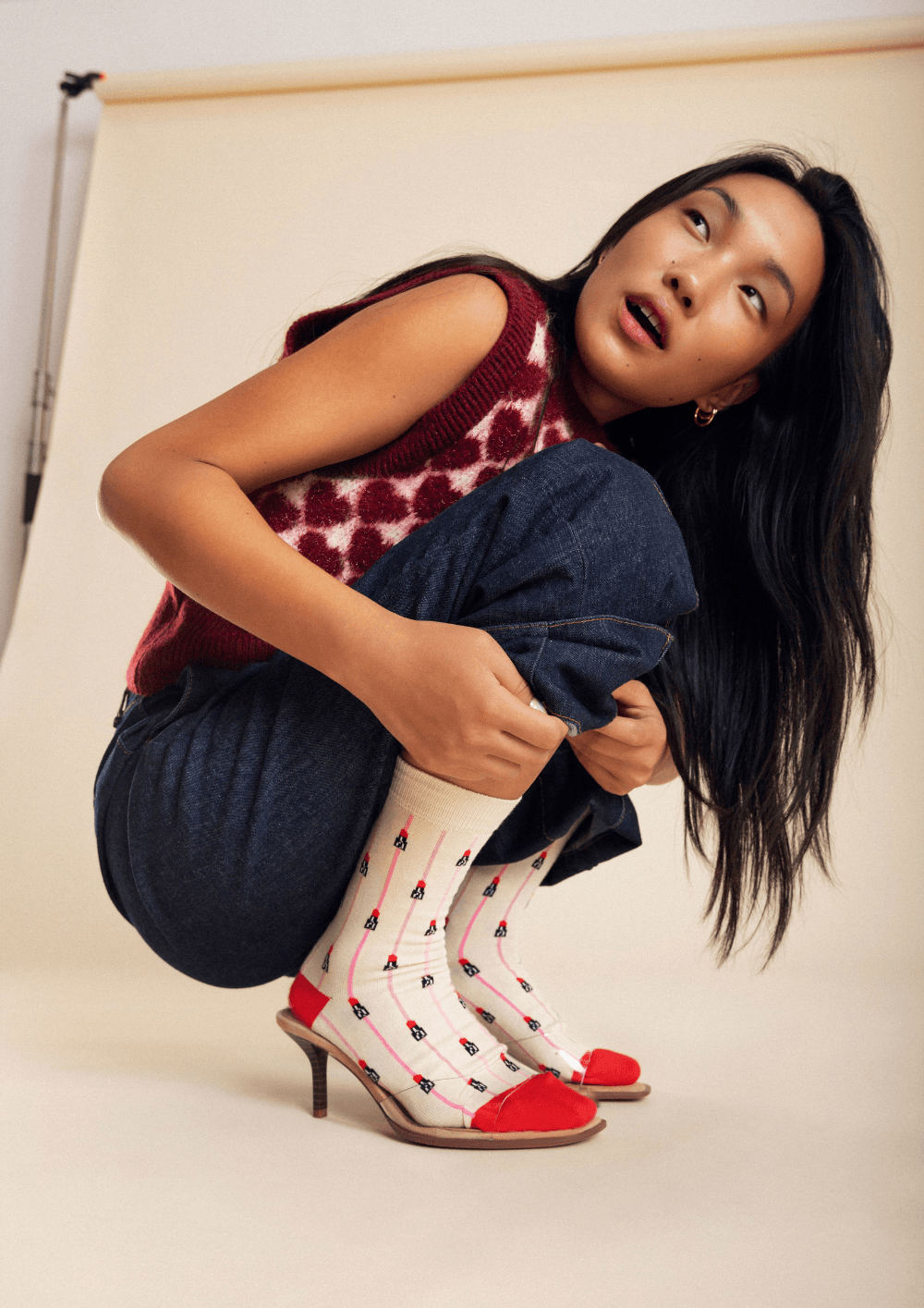 Modelo luciendo tacones con calcetines de estampado divertido, inspirada en el artículo 'Del street style al despacho: la guía definitiva para llevar tacones con calcetines'.