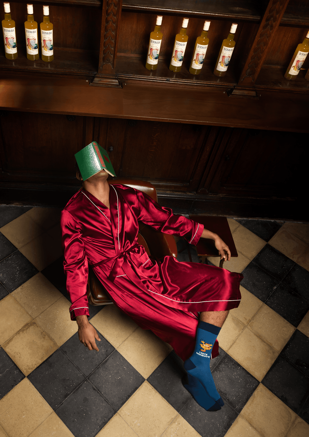 GARFIELD: The art of doing nothing - a relaxed figure in a red robe, with a book on their face and colorful socks.