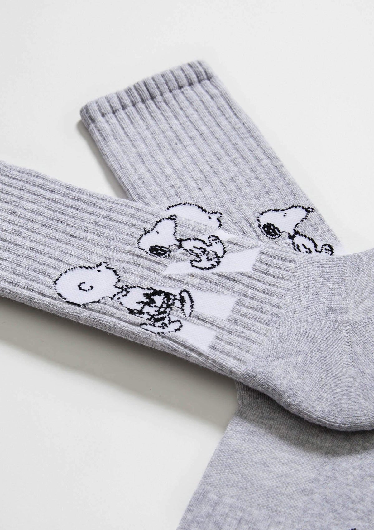 Calcetines BeSnoopy Walk Grey de media caña con diseño de Snoopy y Charlie Brown en negro sobre fondo gris.