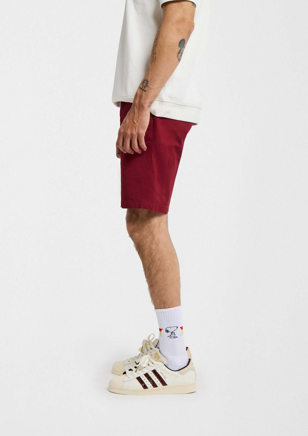 BeSnoopy Rainbow, calcetines altos con dibujos de Snoopy y banda arcoíris sobre fondo blanco, combinados con shorts rojos.
