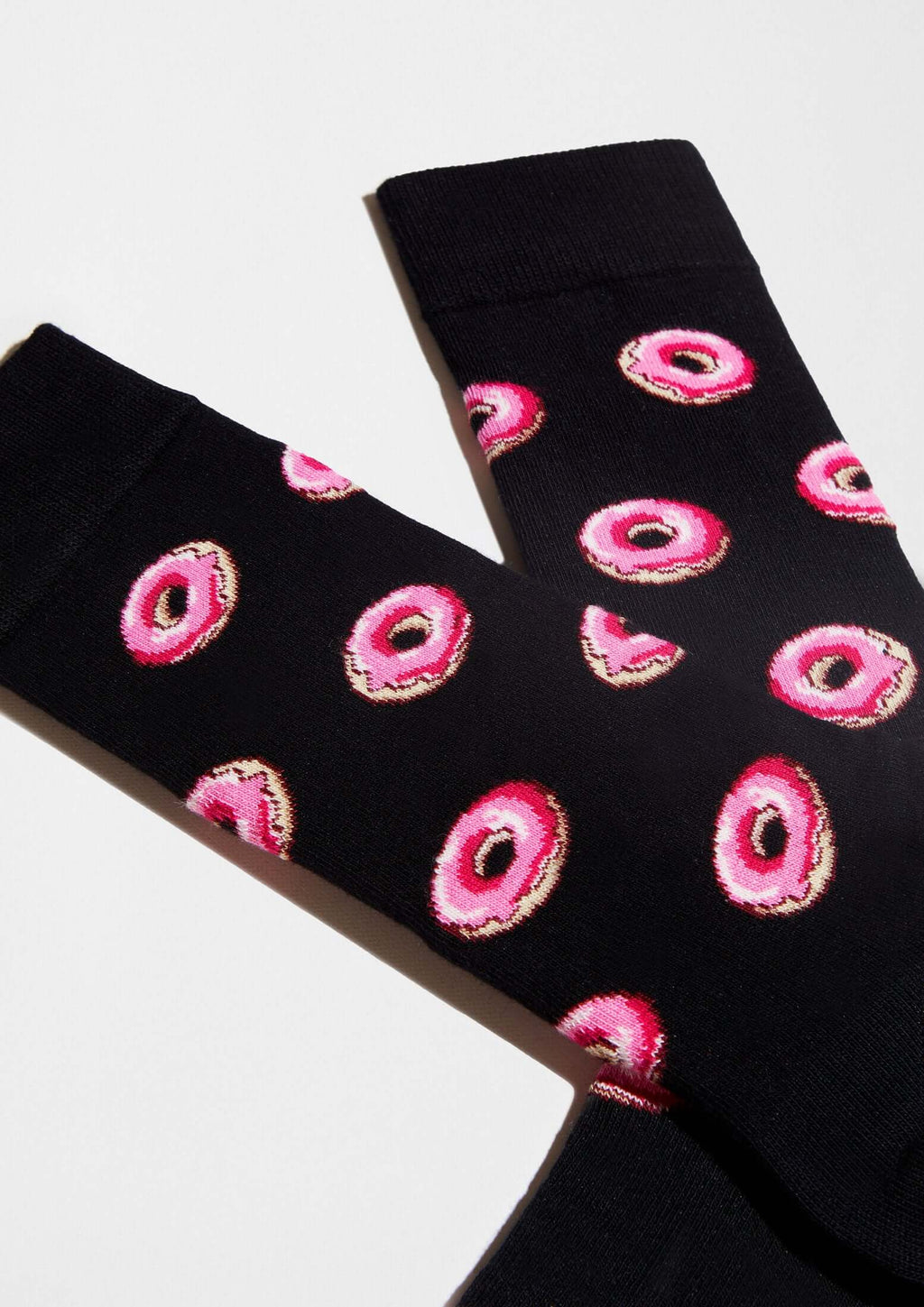 Calcetines originales BeDonut Black con diseño de donuts en glaseado rosa sobre fondo negro.