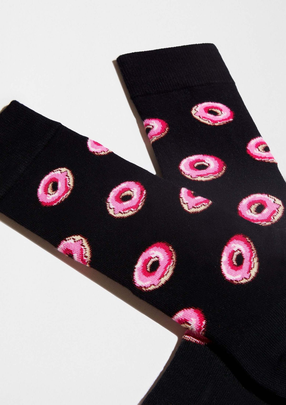 Calcetines originales BeDonut Black con diseño de donuts en glaseado rosa sobre fondo negro.