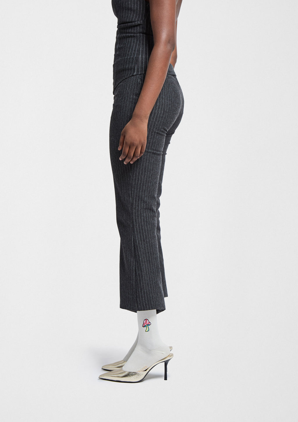 BeMushroom Embroidered Navy en calcetín gris con bordado de seta, combinado con pantalones de rayas y tacones.