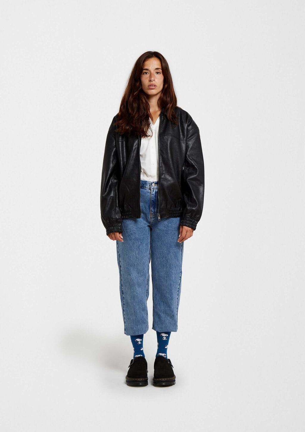 Mujer con chaqueta de cuero negra y calcetines BeSnoopy azules - BESOCKS