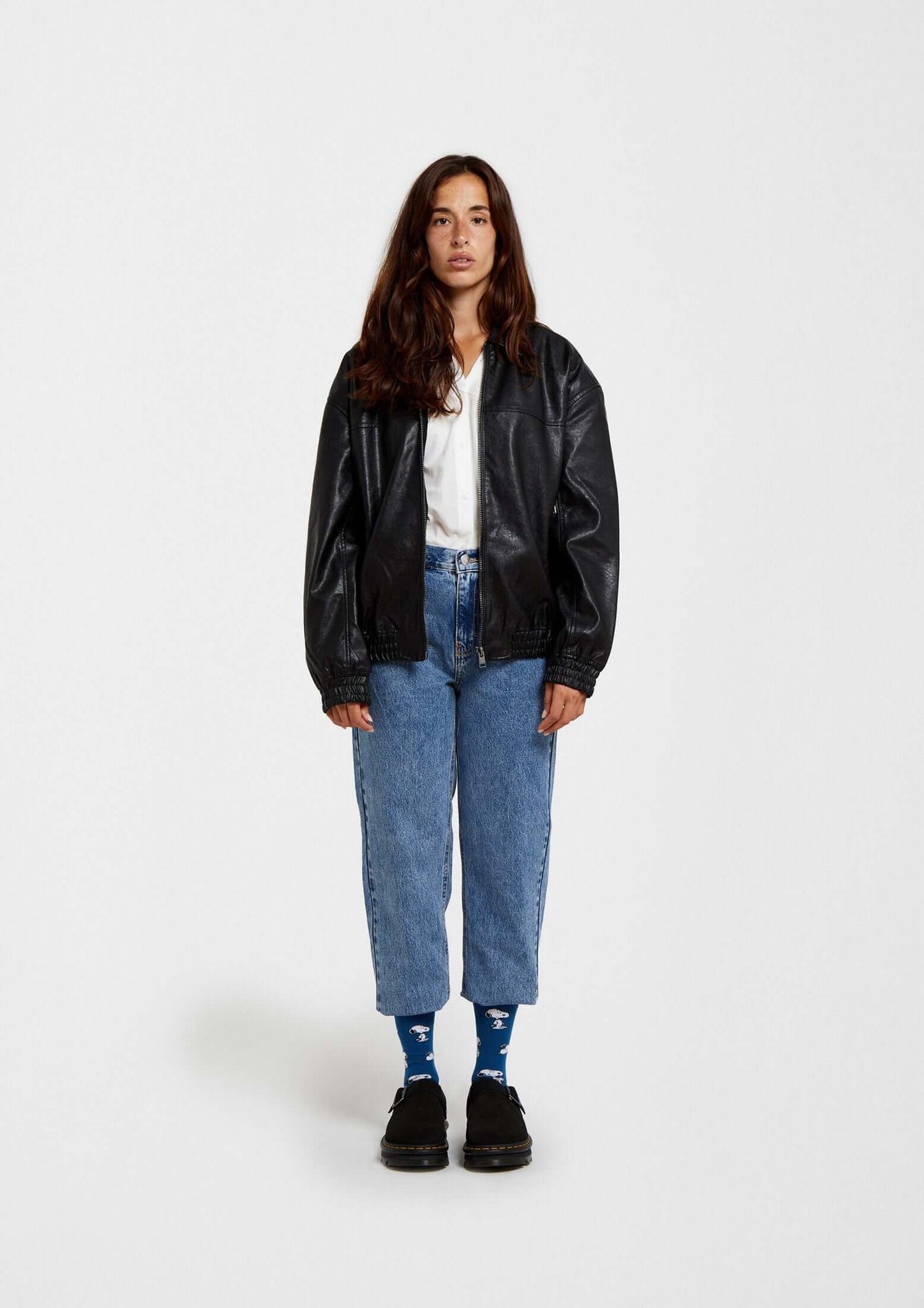 Mujer con chaqueta de cuero negra y calcetines BeSnoopy azules - BESOCKS