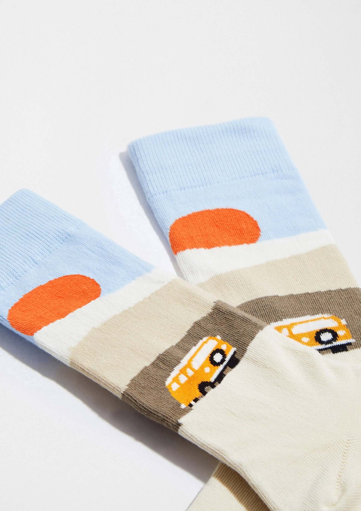 calcetines originales BeRoadTrip con diseño de furgoneta en el desierto y sol naranja, perfectos para los amantes de la carretera.