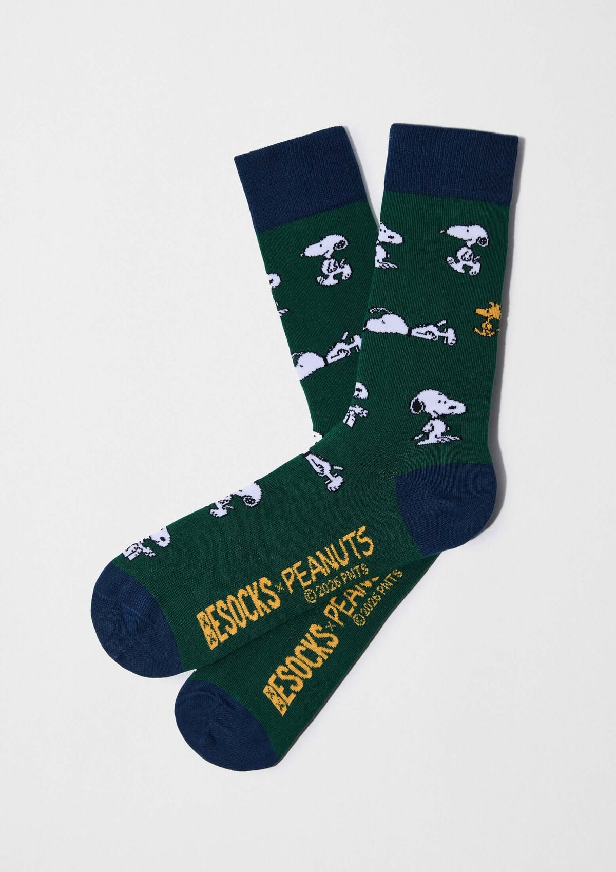 Calcetines altos BeSnoopy Green con dibujos de Snoopy en fondo verde botella y detalles en azul marino.