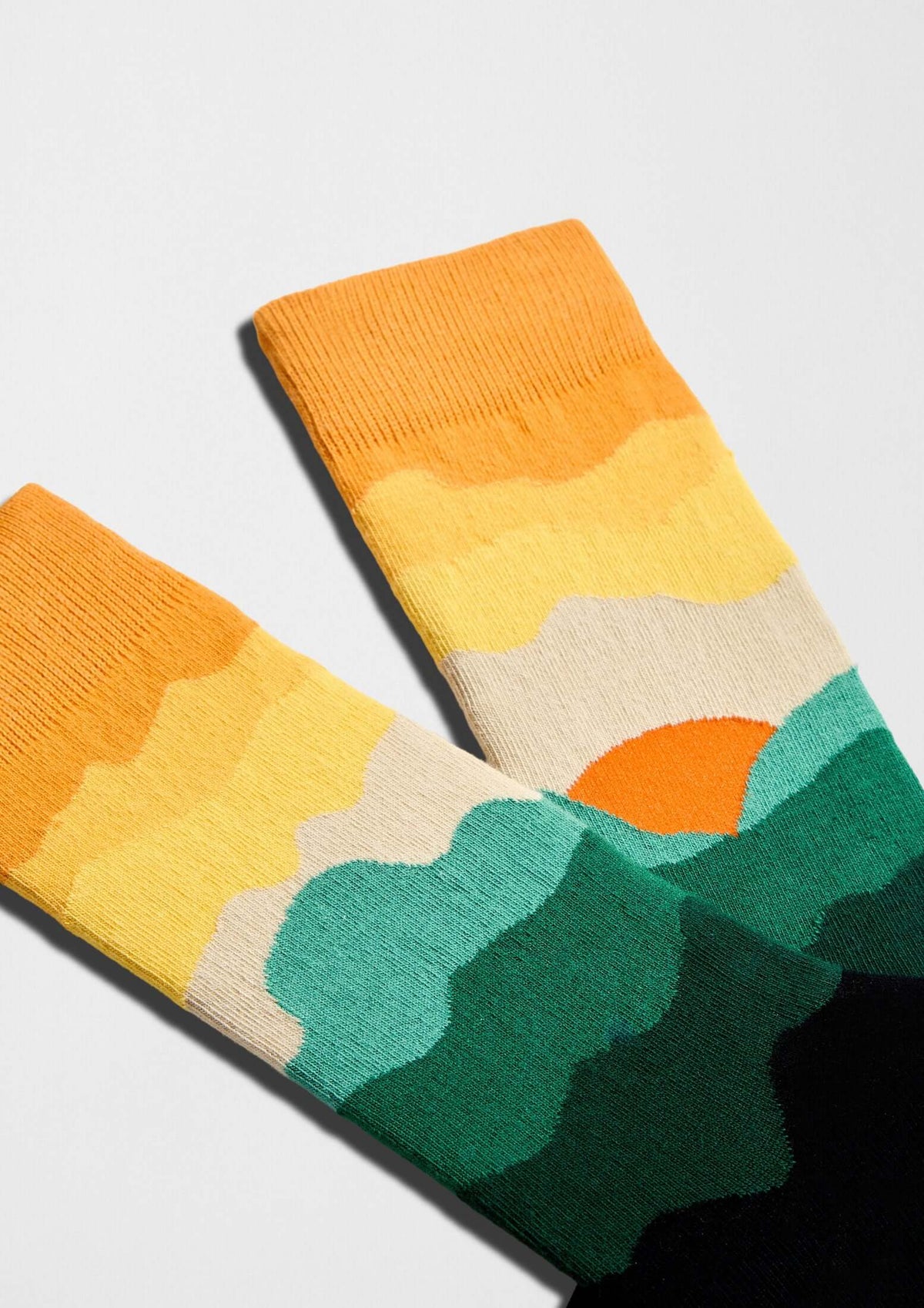 Diseño de calcetines BeMountain con montañas en degradado naranja y verde - BESOCKS
