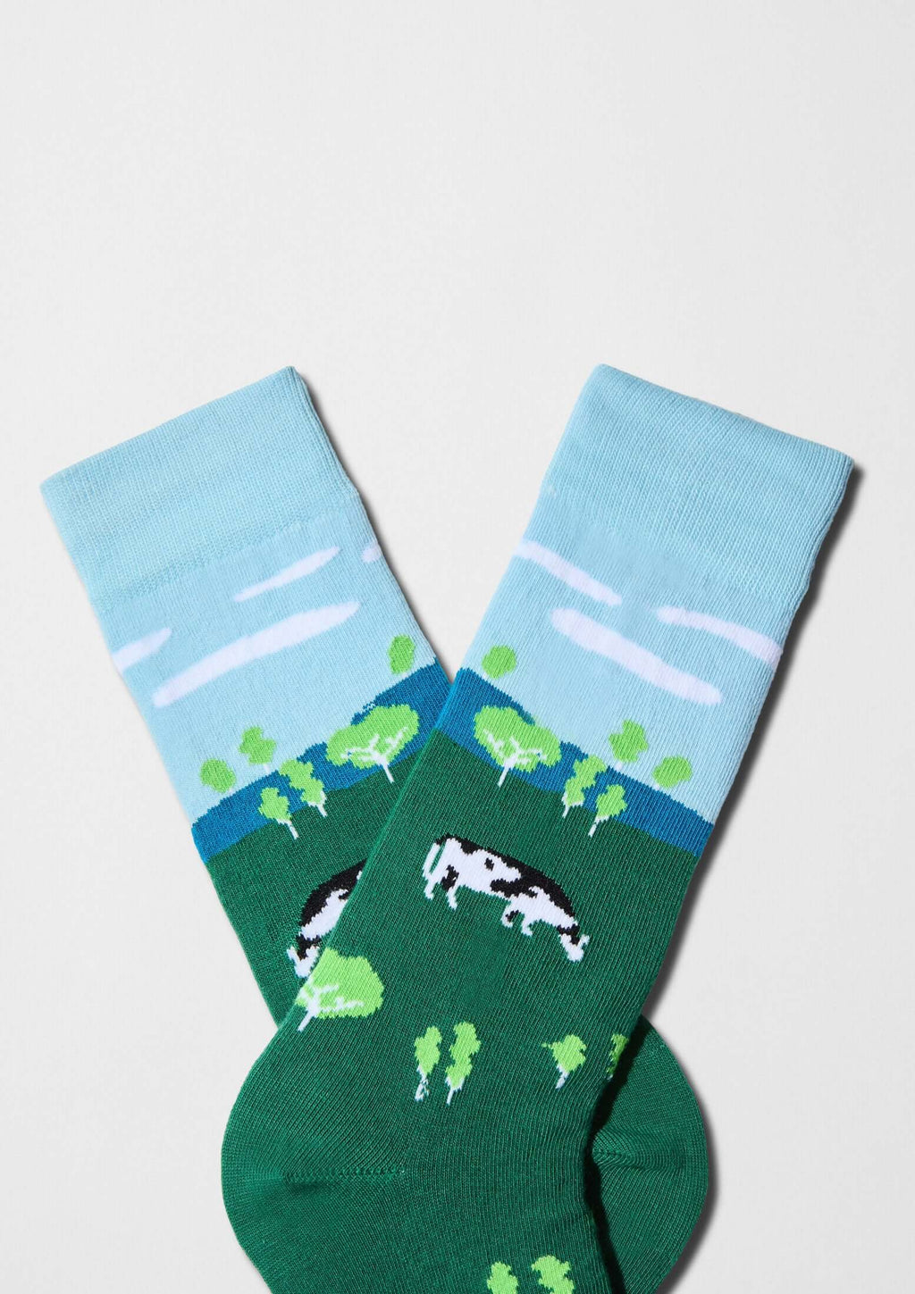Calcetines BeFarm con paisaje rural, vaca y árboles en verde y puño azul cielo - BESOCKS