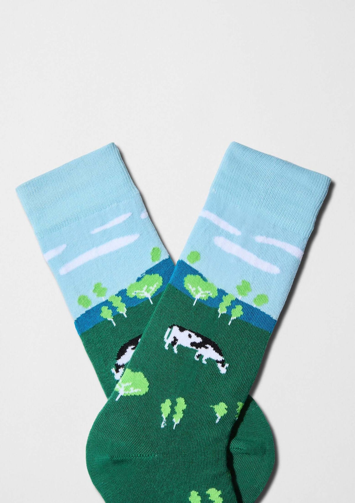 Calcetines BeFarm con paisaje rural, vaca y árboles en verde y puño azul cielo - BESOCKS
