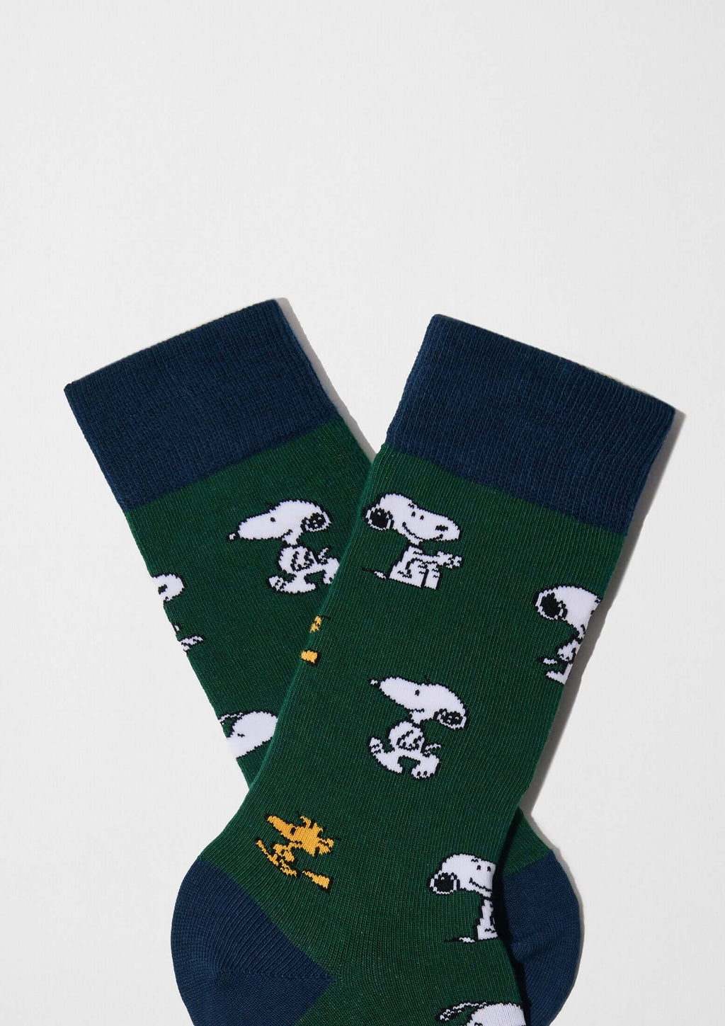 Calcetines altos BeSnoopy Green con dibujos de Snoopy sobre fondo verde y detalles en azul marino, algodón orgánico.