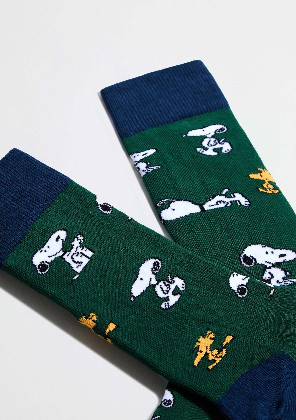 Calcetines altos BeSnoopy Green de algodón orgánico con dibujos de Snoopy sobre fondo verde y detalles en azul.