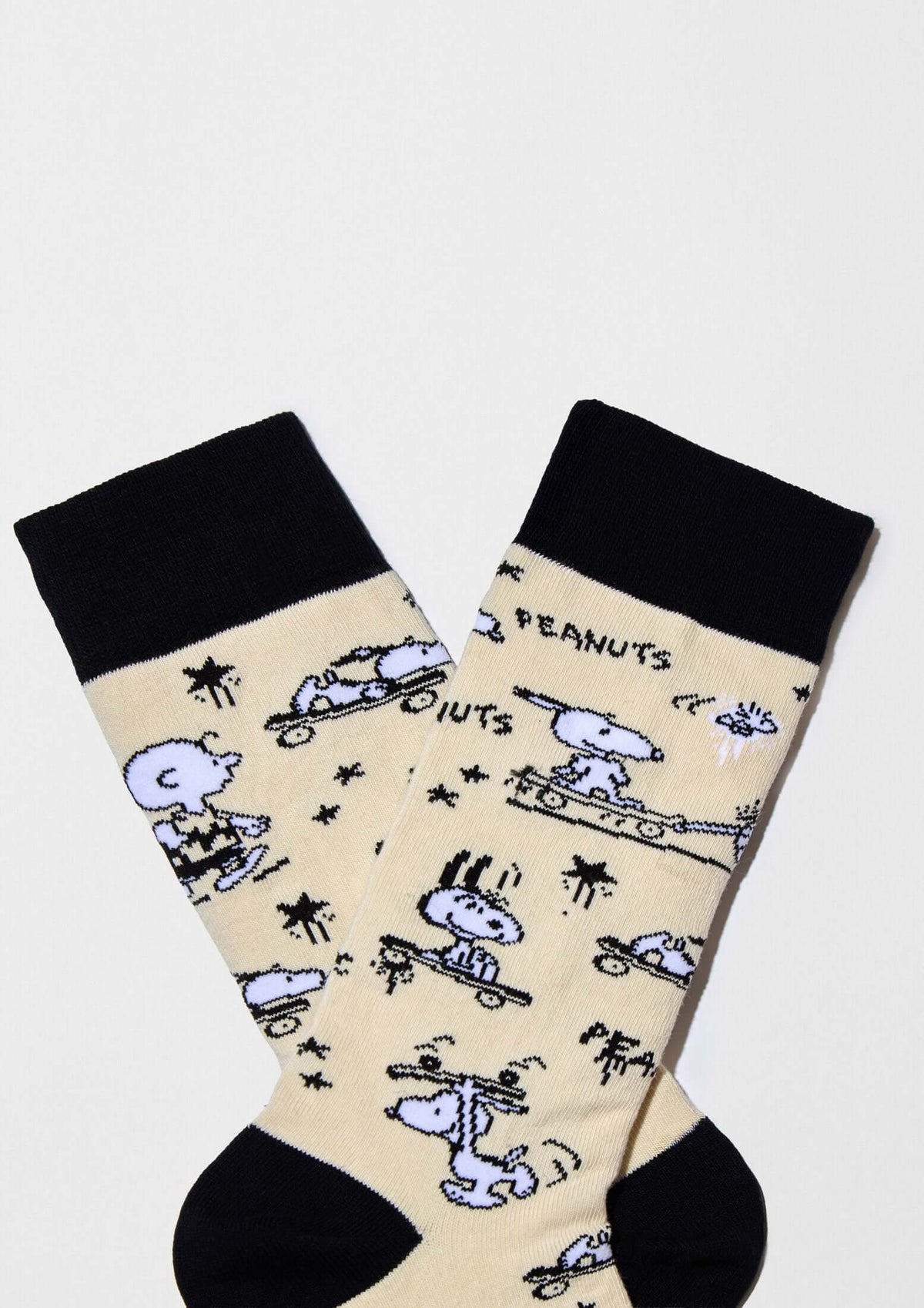 Calcetines altos BeSnoopy Skate Beige con dibujos de Snoopy y Charlie Brown sobre fondo beige y detalles en negro.