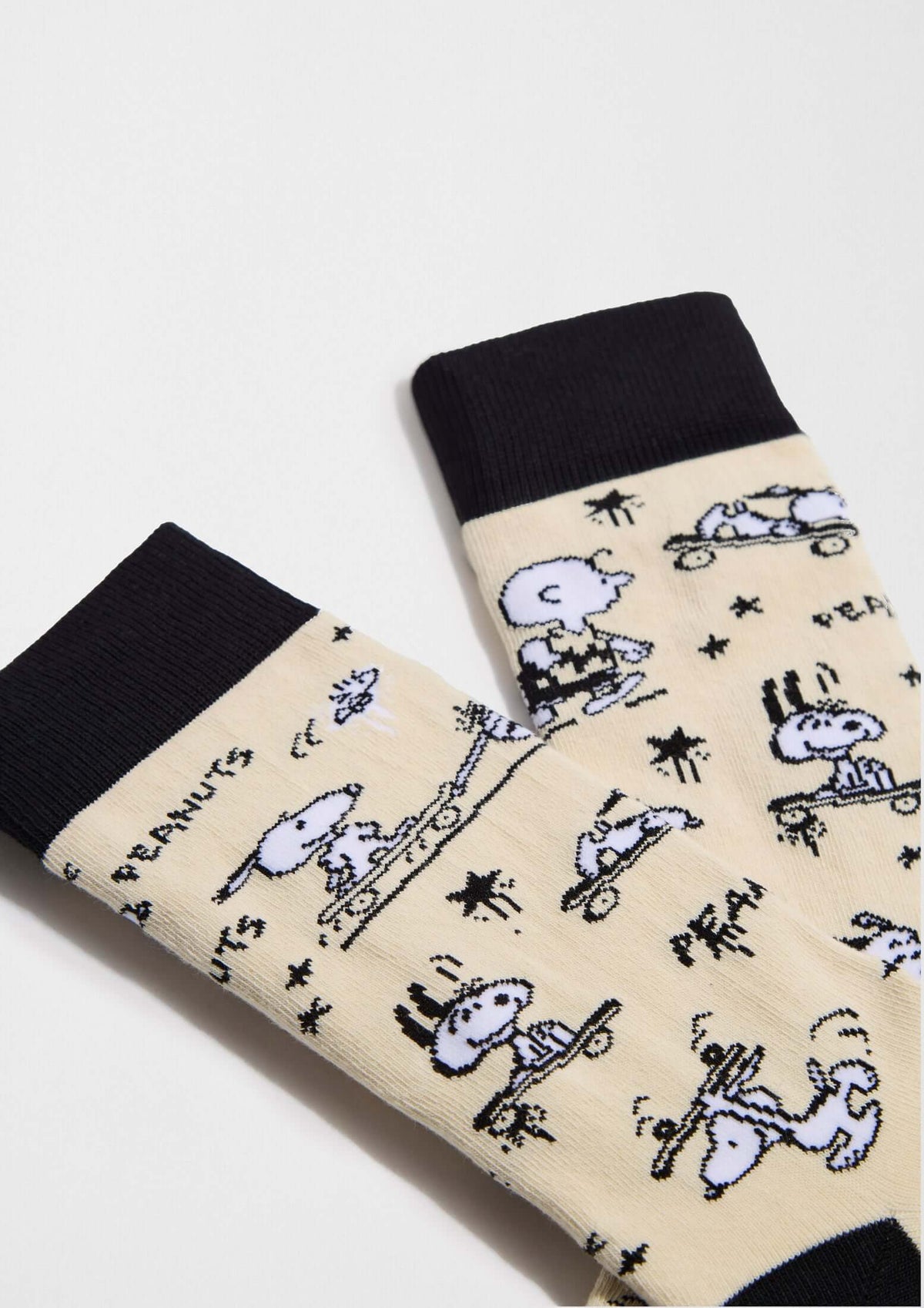 Calcetines altos BeSnoopy Skate Beige con dibujos de Snoopy y Charlie Brown sobre fondo beige y detalles en negro.