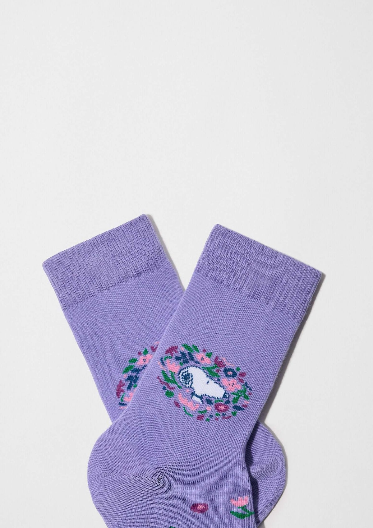 Calcetines altos BeSnoopy Blossom en color lila con dibujos de Snoopy sobre fondo con flores y círculos.
