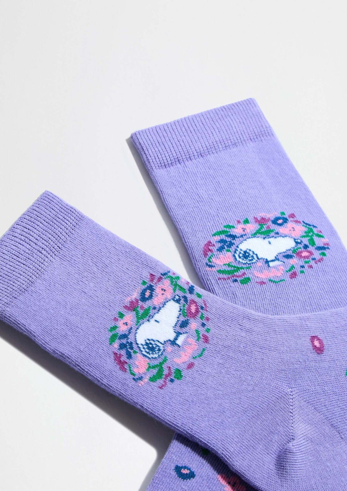 Calcetines altos BeSnoopy Blossom de fondo lila con dibujos de Snoopy y flores coloridas en algodón orgánico.