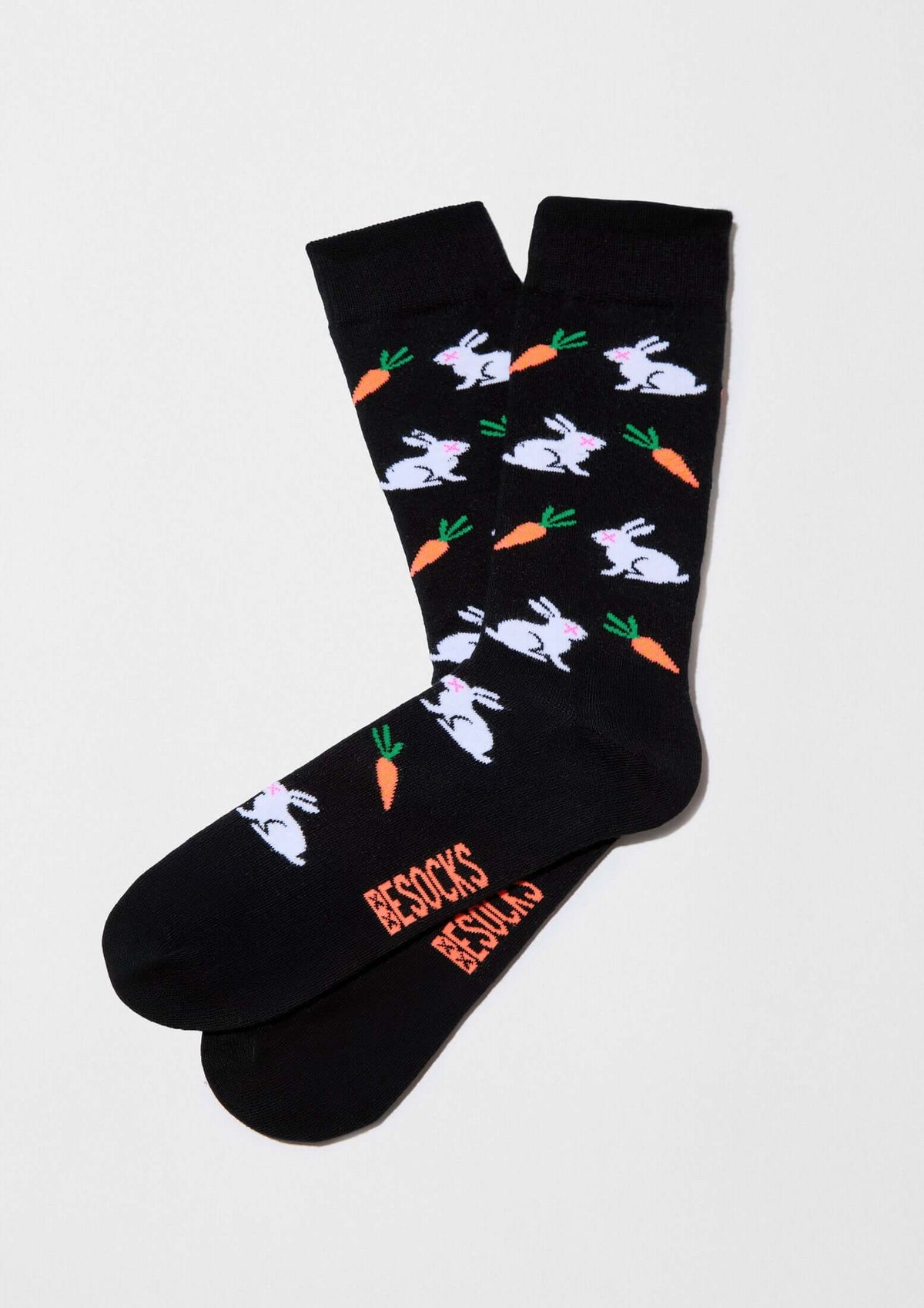Calcetines BeRabbit de algodón orgánico en negro con dibujos de conejos y zanahorias en color blanco y naranja.