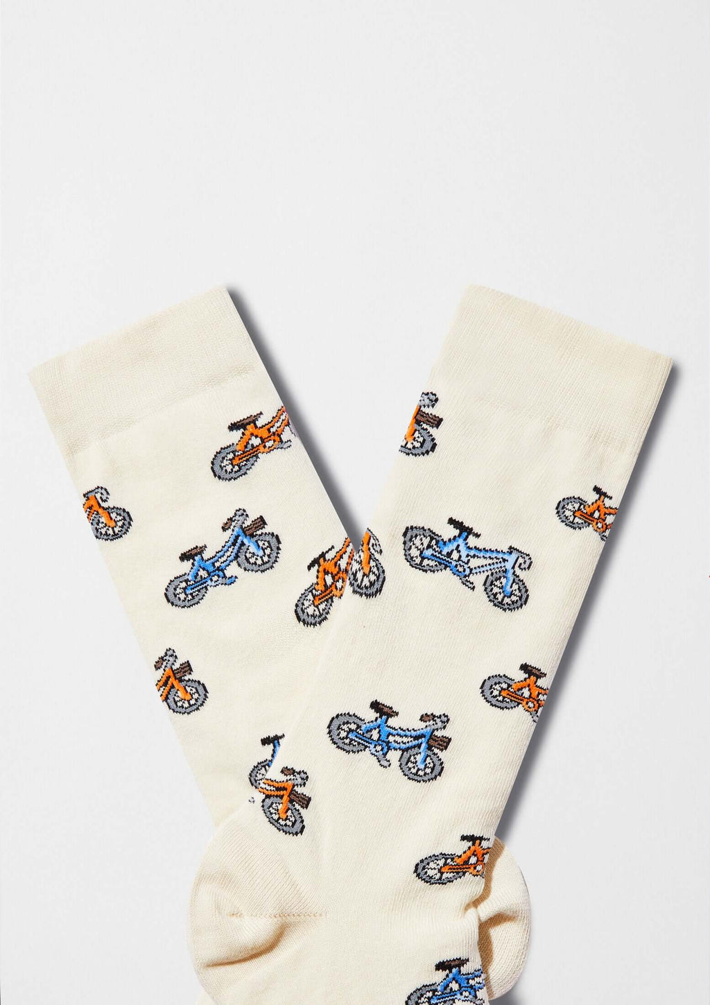 calcetines originales BeBicycle Beige con dibujos de bicicletas en tonos azul y naranja sobre fondo beige claro.
