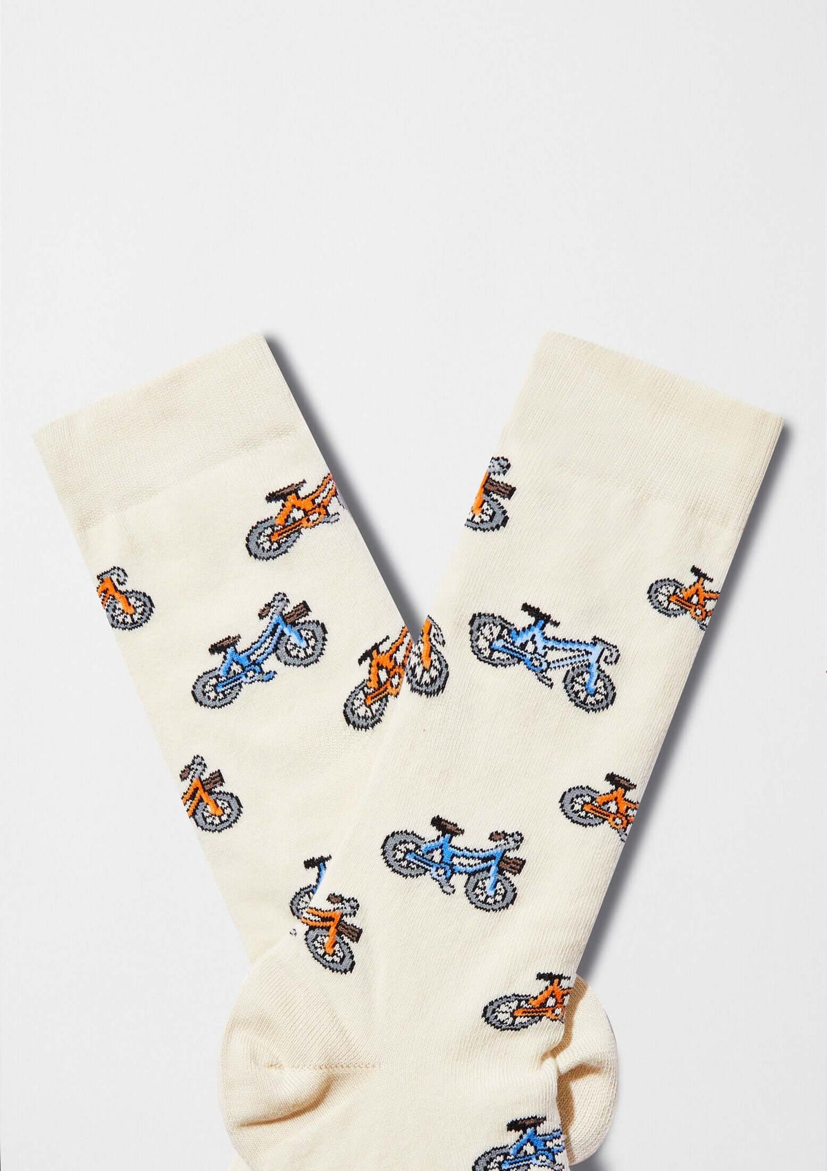 calcetines originales BeBicycle Beige con dibujos de bicicletas en tonos azul y naranja sobre fondo beige claro.