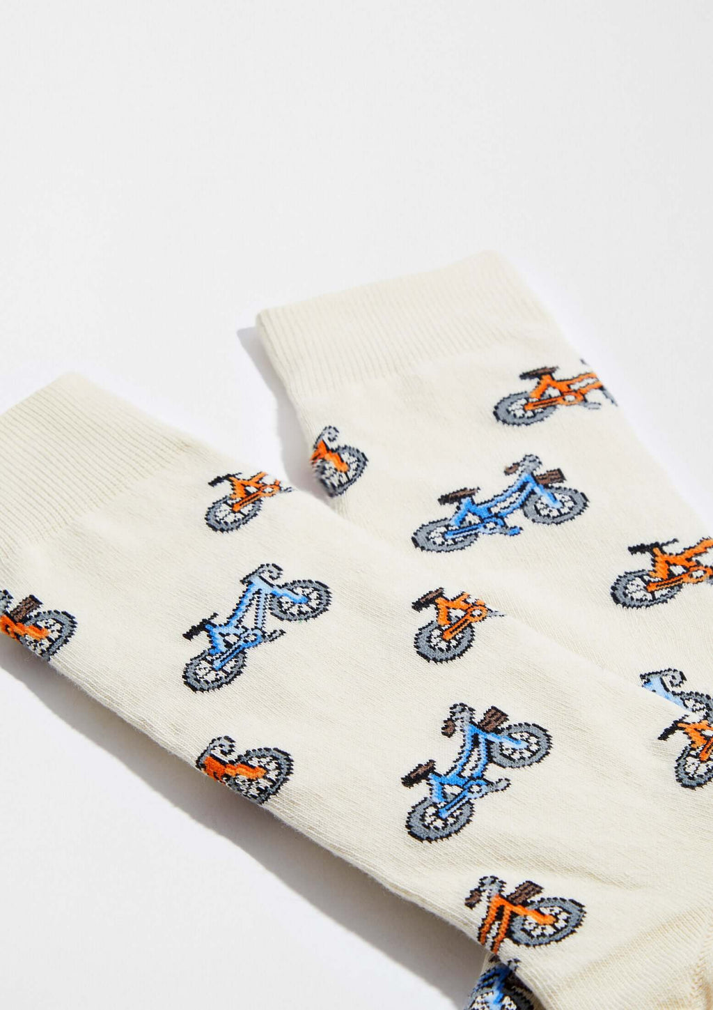 calcetines originales BeBicycle Beige con dibujos de bicicletas en tonos azul y naranja sobre fondo beige claro.