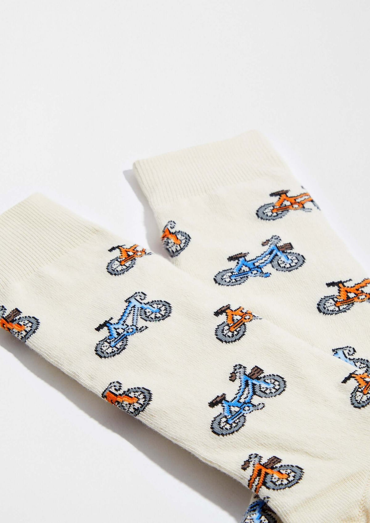 calcetines originales BeBicycle Beige con dibujos de bicicletas en tonos azul y naranja sobre fondo beige claro.