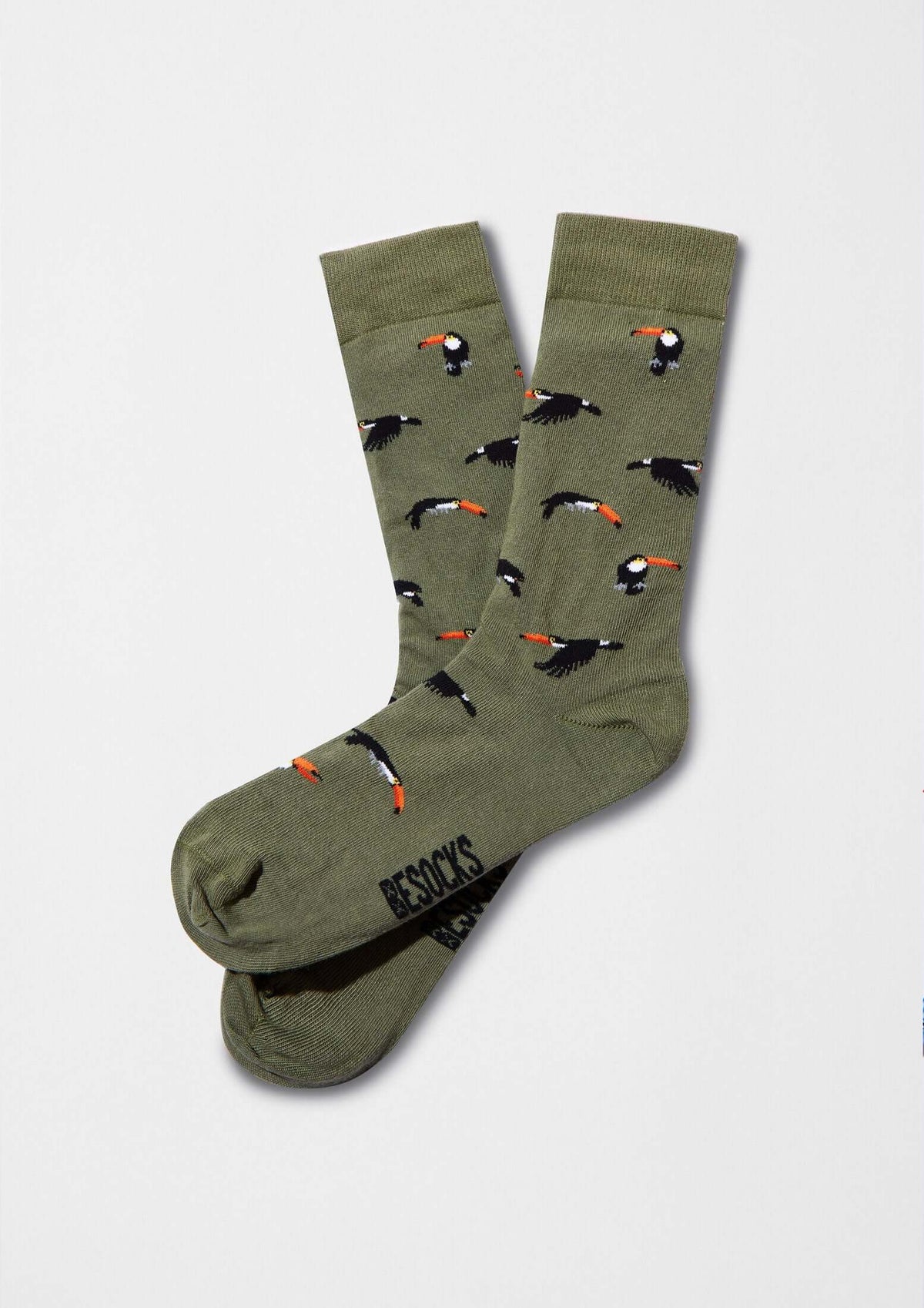 Calcetines BeToucan Green con dibujos de tucanes en vuelo sobre base verde oliva, ideales para un look original.