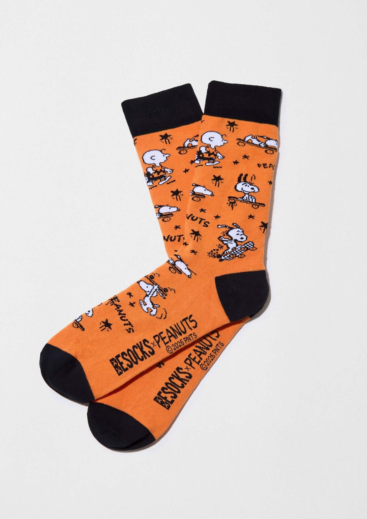 Calcetines altos BeSnoopy Skate Orange en fondo naranja con dibujos de Snoopy y Charlie Brown, detalles en negro.