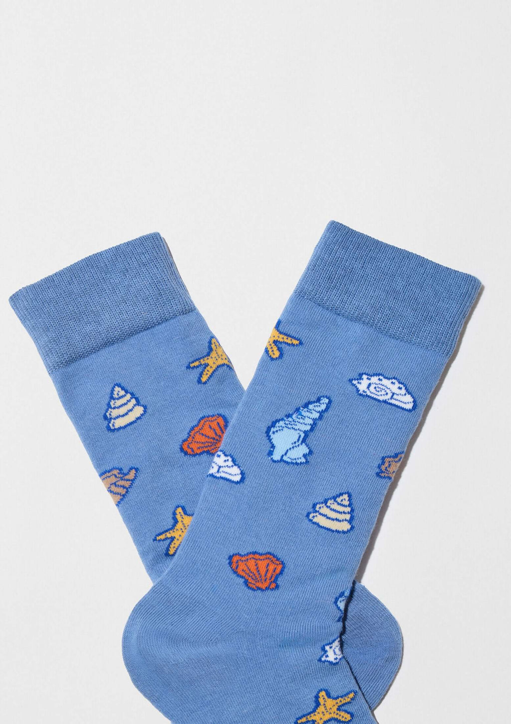 Calcetines BeOcean Blue en azul con dibujos de conchas marinas en tonos cálidos y fríos de estilo original.