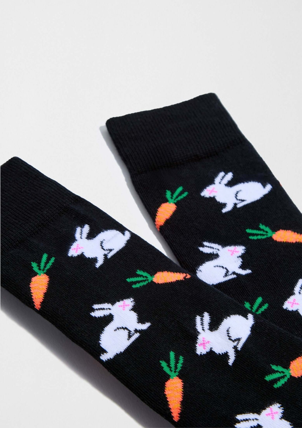 Calcetines BeRabbit en negro con dibujos de conejos y zanahorias en tonos blanco y verde, ideales para looks informales.