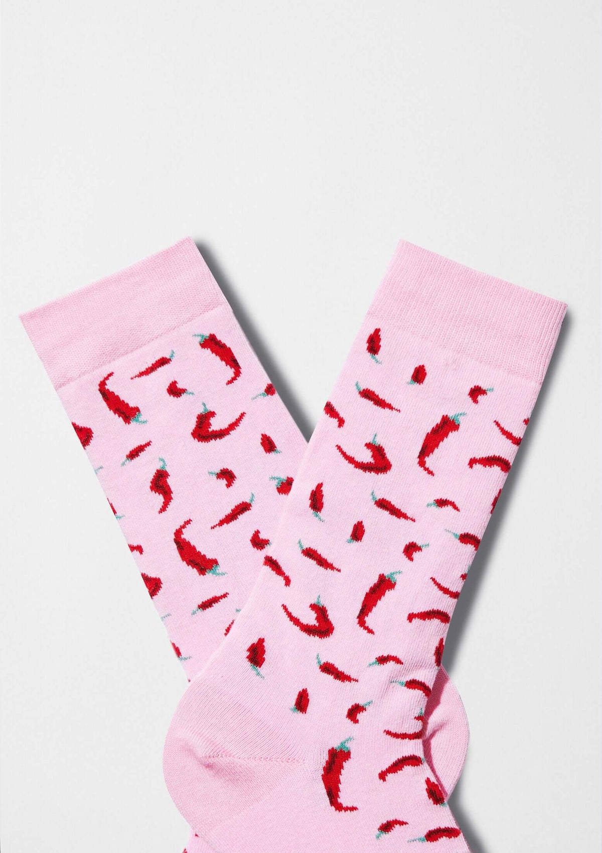 Calcetines BeChili Pink con gráfico de chiles rojos sobre fondo rosa claro, diseño divertido y original.