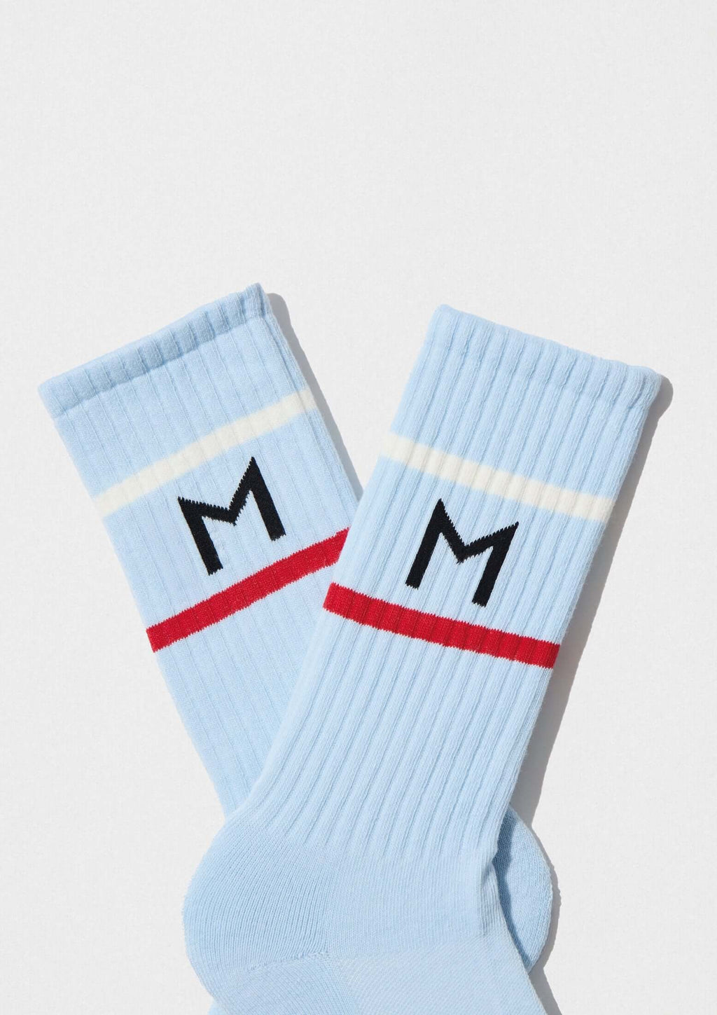 calcetines BeMOISESNIETO Light Blue con franjas deportivas y logo 'M' en color celeste.