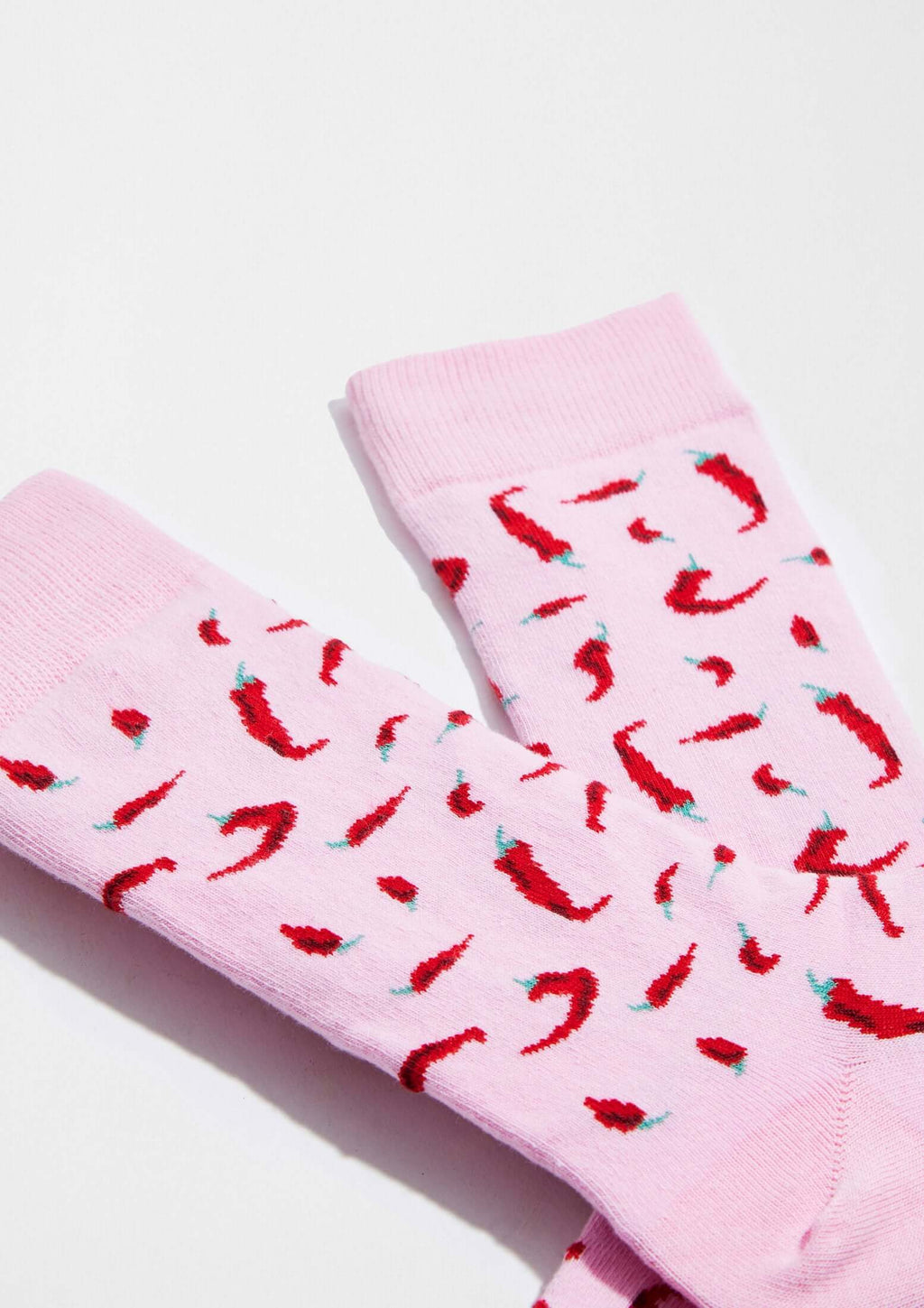 Calcetines BeChili Pink con dibujos de chiles rojos sobre fondo rosa claro, de la marca BESOCKS.