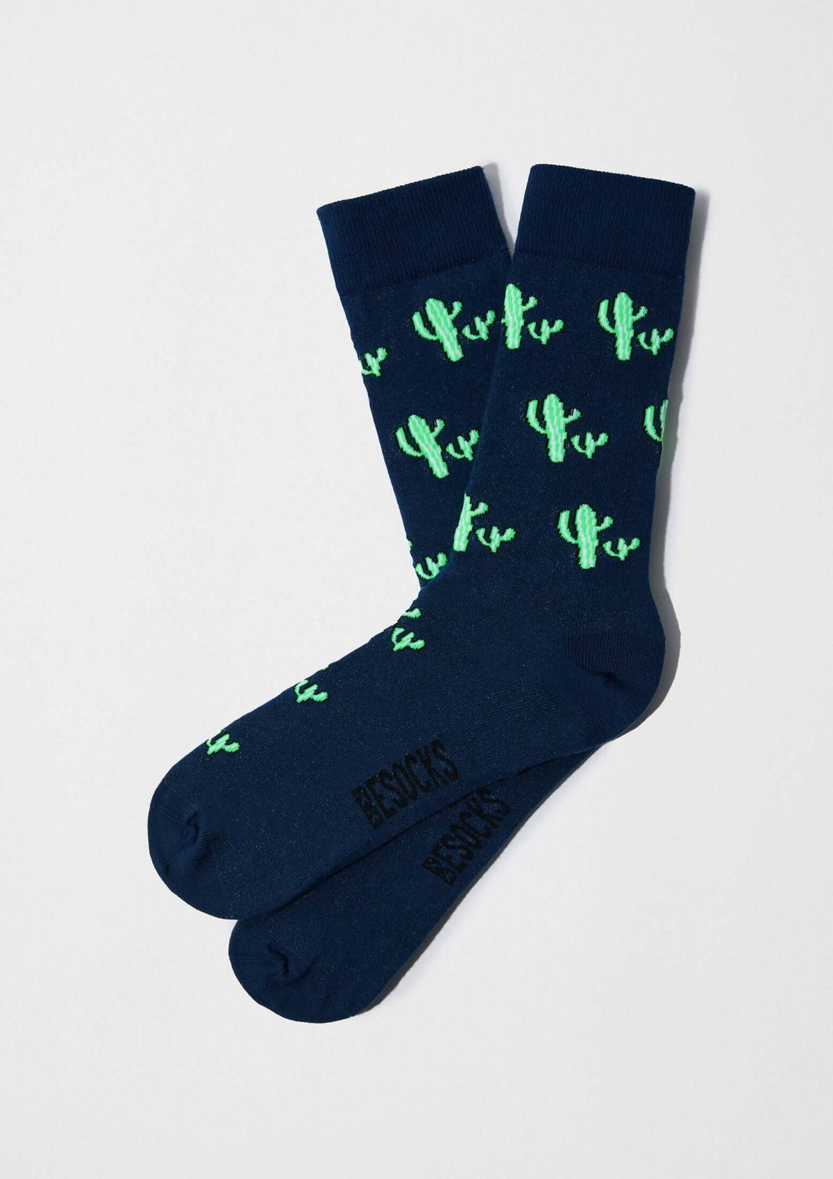 Calcetines BeCactus Navy de algodón, fondo azul marino con cactus verdes, diseño original y moderno.