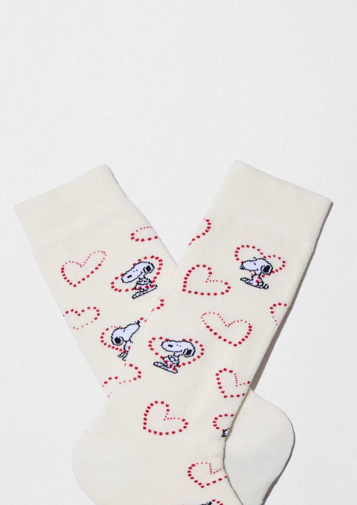 Calcetines altos BeSnoopy Heart Off White con dibujos de Snoopy y corazones sobre fondo blanco roto.