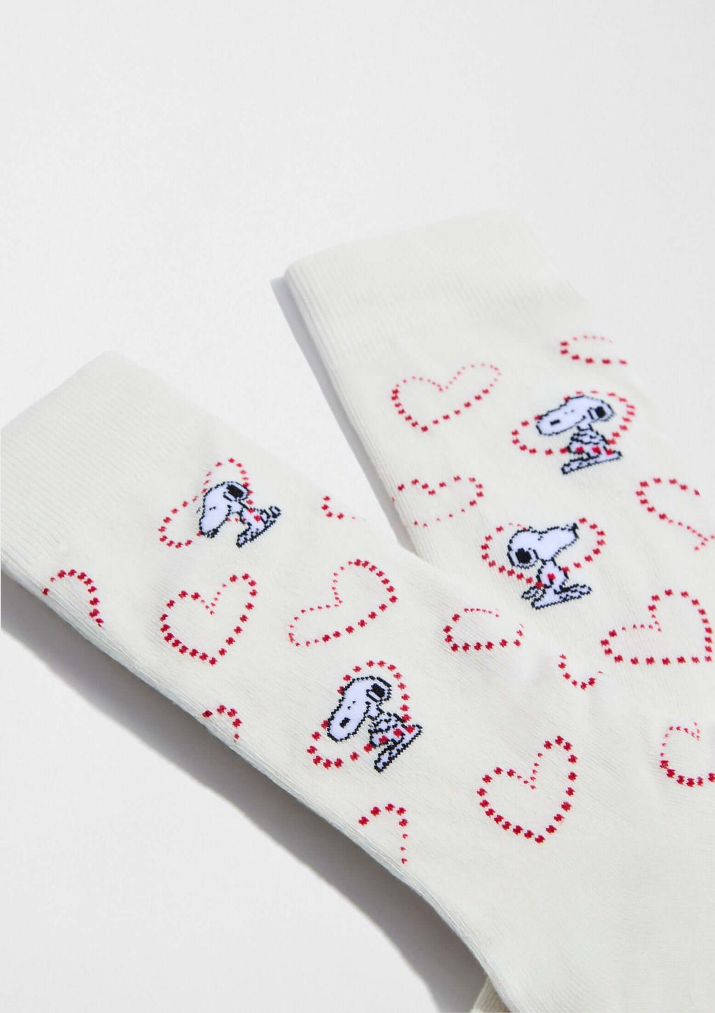Calcetines altos BeSnoopy Heart Off White de algodón orgánico con dibujos de Snoopy sobre fondo blanco y corazones rojos.