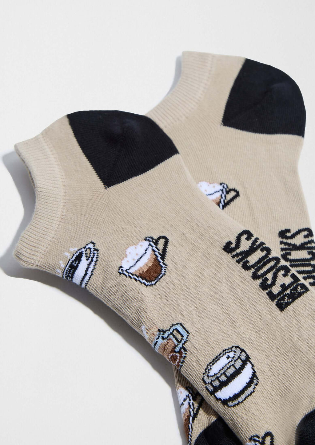 BeCoffee Beige Ankle, calcetines tobilleros color beige con ilustraciones de tazas de café y talón negro. Fabricados en Portugal.