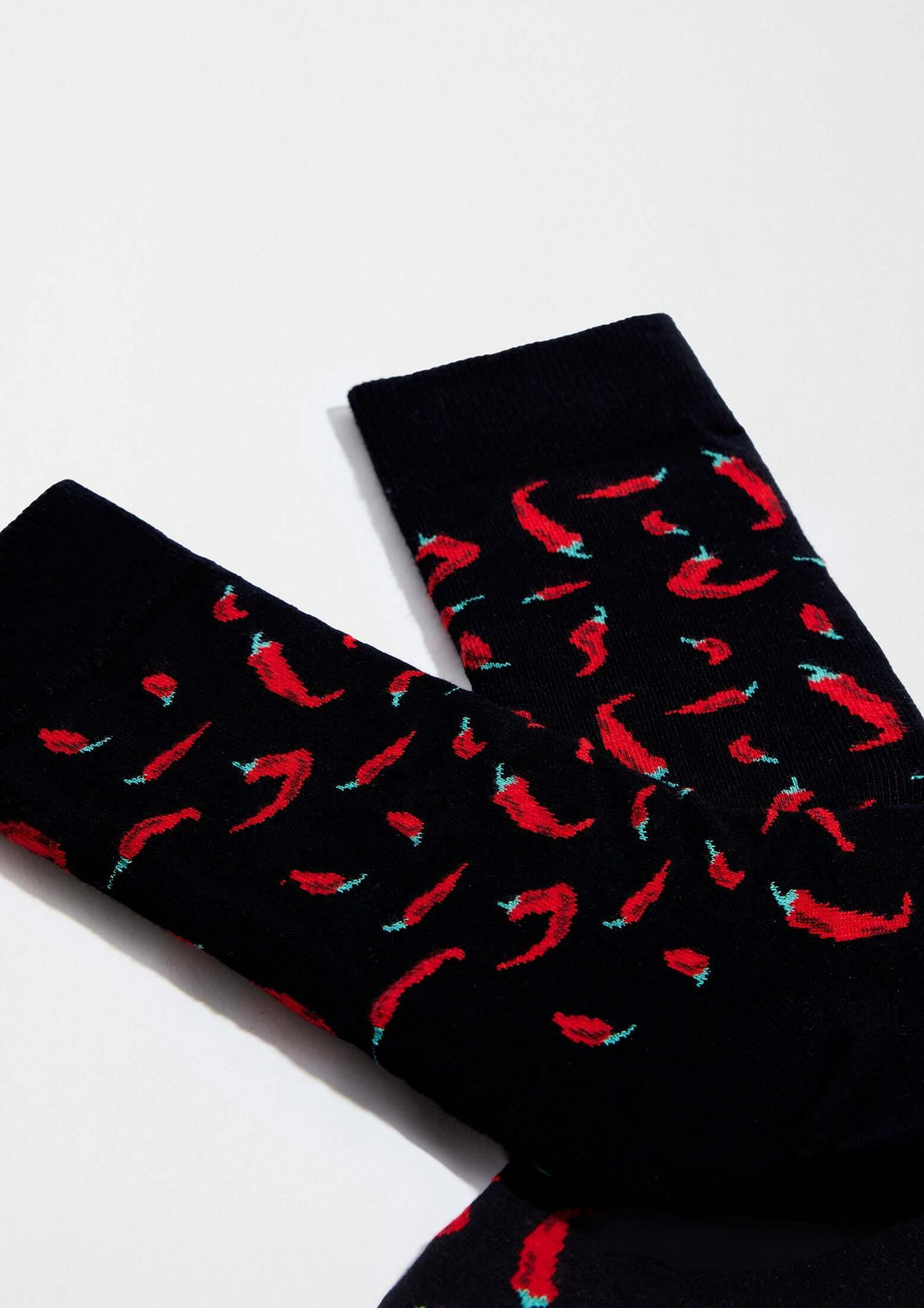 Calcetines BeChili Black con dibujos de chiles rojos sobre fondo negro, ideal para un toque divertido.
