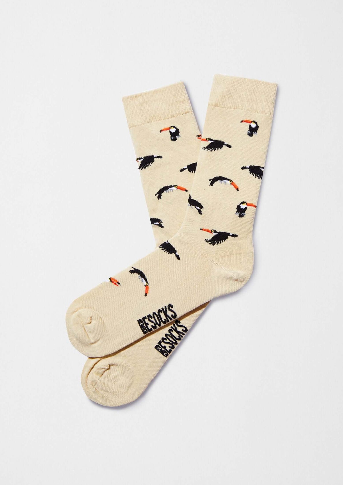 Calcetines originales BeToucan Beige con tucanes en diferentes posiciones, fondo beige claro.