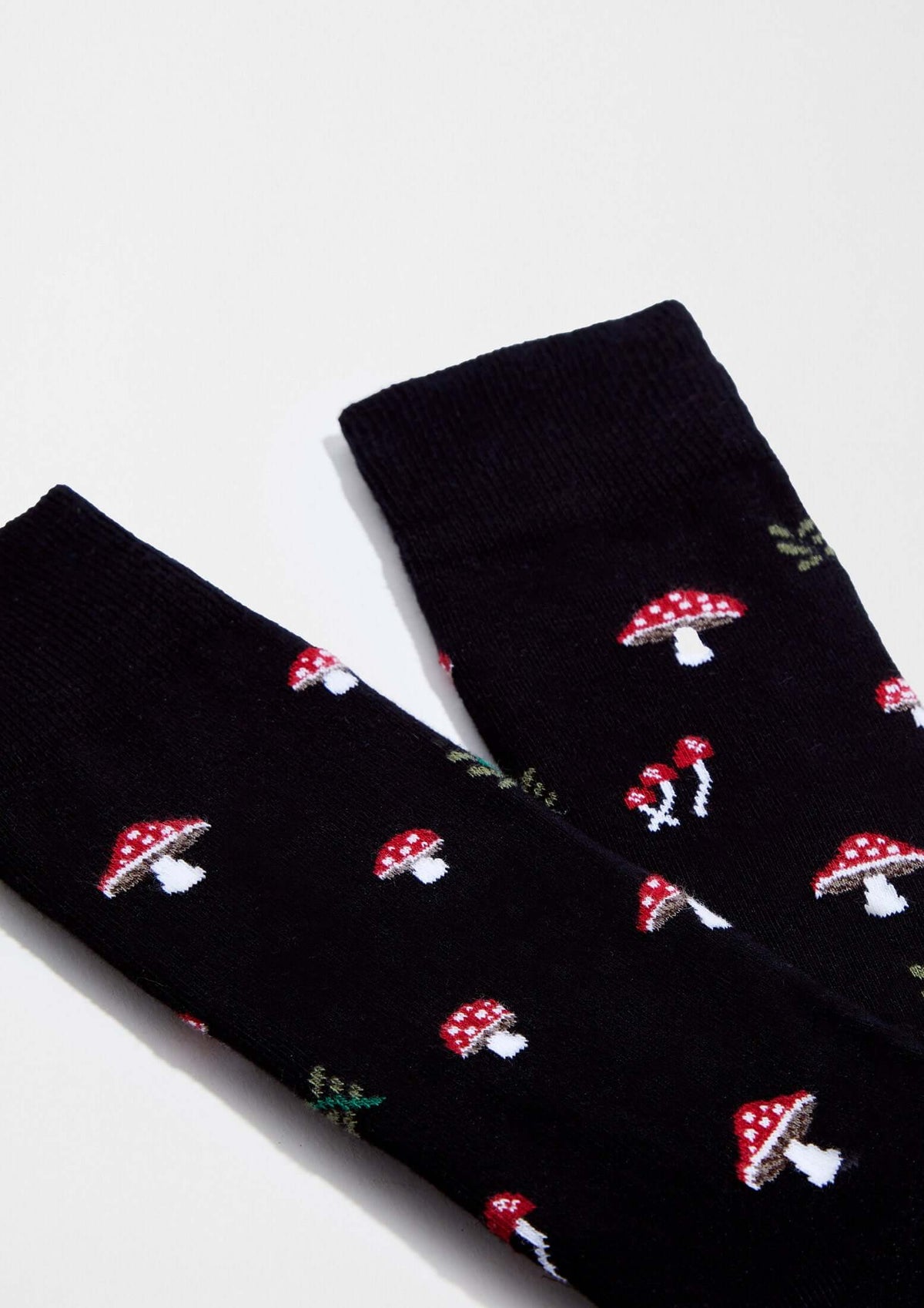 Calcetines originales BeMushroom Black con dibujos de setas rojas sobre fondo negro.