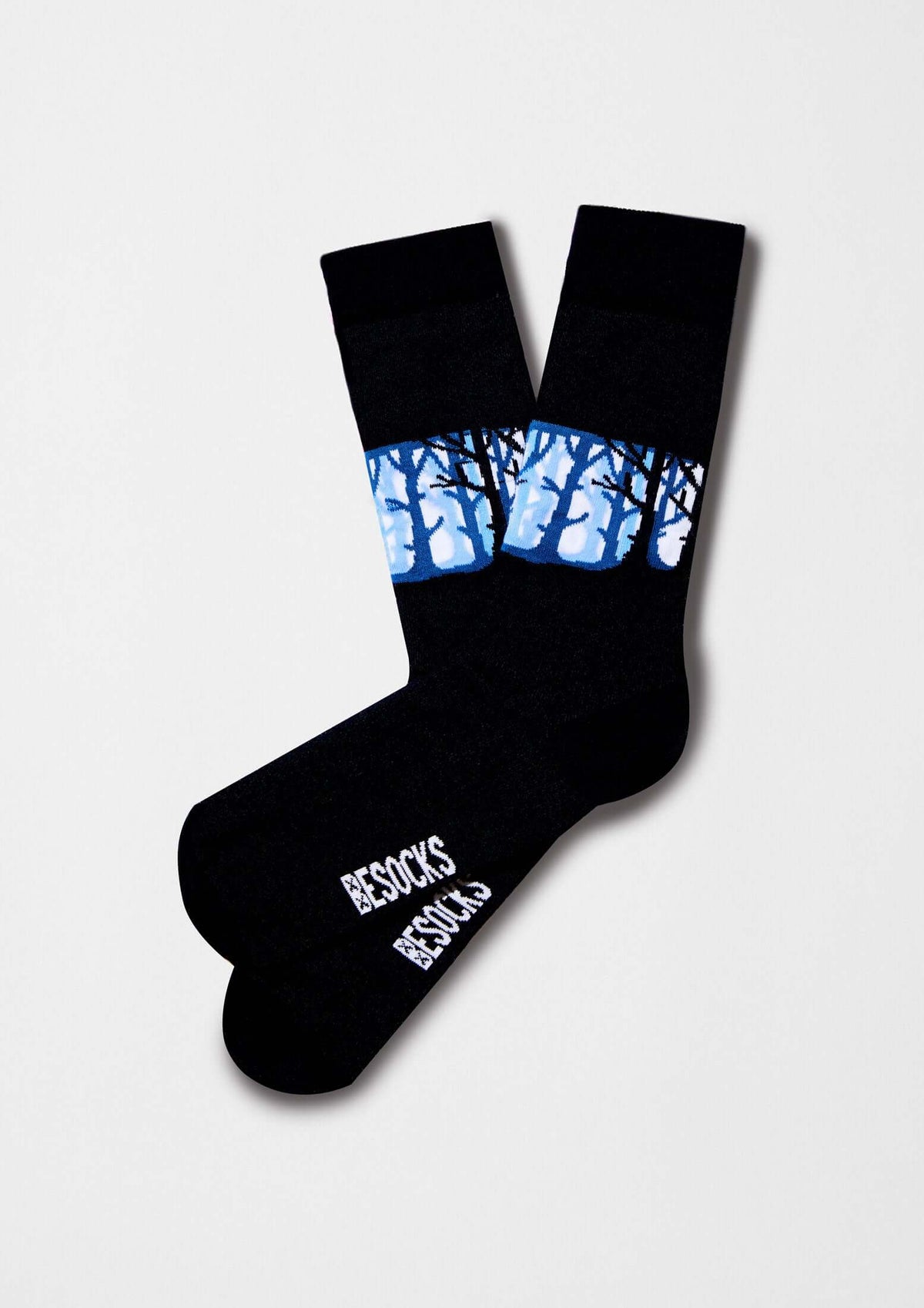 Calcetines BeWoods con dibujos de un bosque negro y azul sobre base negra, diseño elegante y original.