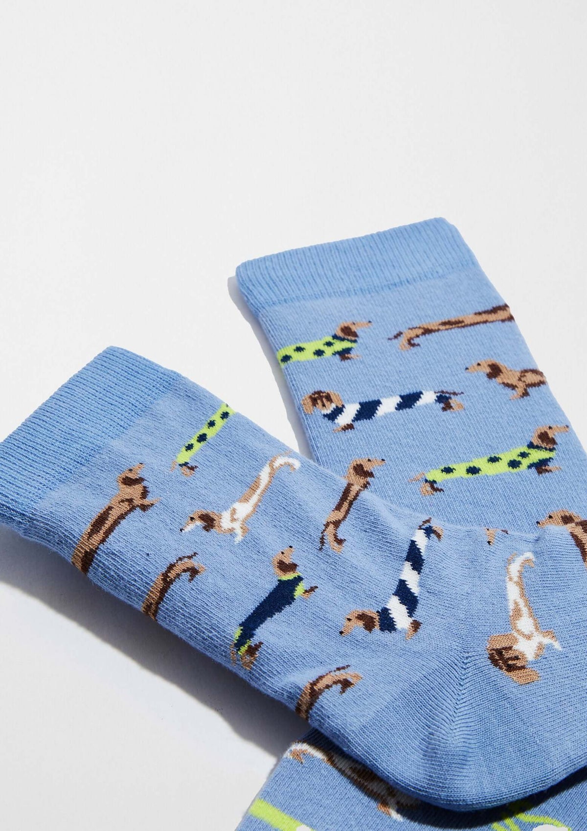 Calcetines BePets Woman Blue de caña baja en azul claro con estampado de perros salchicha en diversas posiciones.