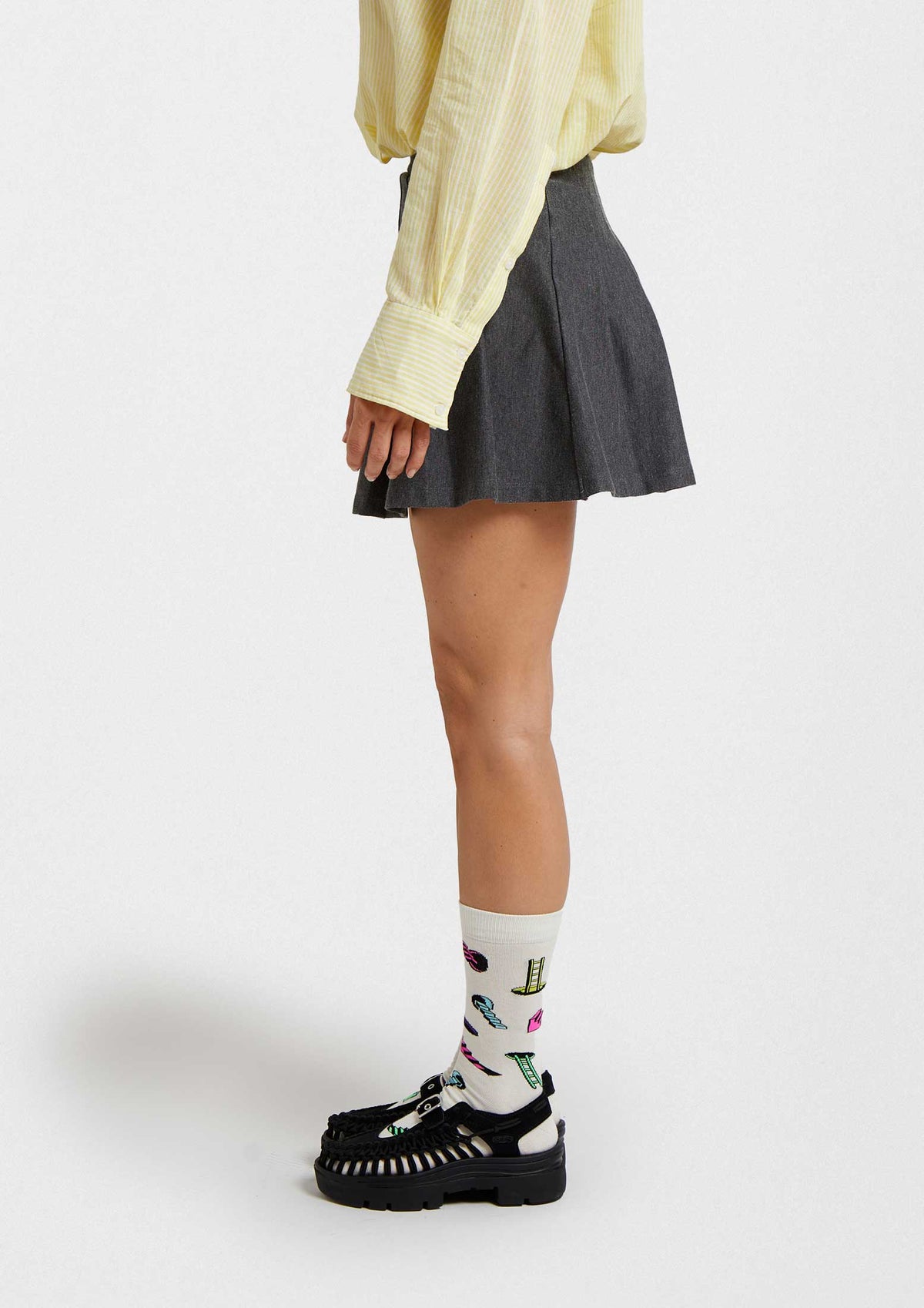 Mujer usando calcetines originales BeBlackHole con dibujos coloridos de escaleras y agujeros negros.