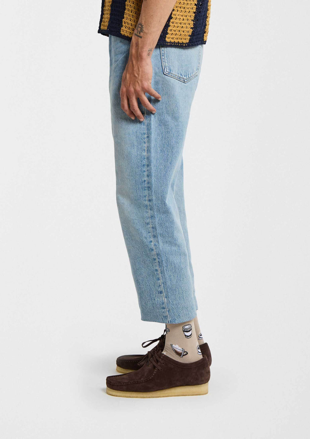 BeCoffee Blue calcetines originales con tazas de café en estilo pixel art, combinados con jeans claros y zapatos marrones.