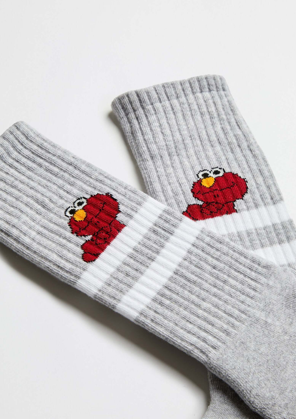 Calcetines BeSesameStreet Elmo Grey con fondo gris y estampado de Elmo en rojo, diseño tobillero con franjas blancas.