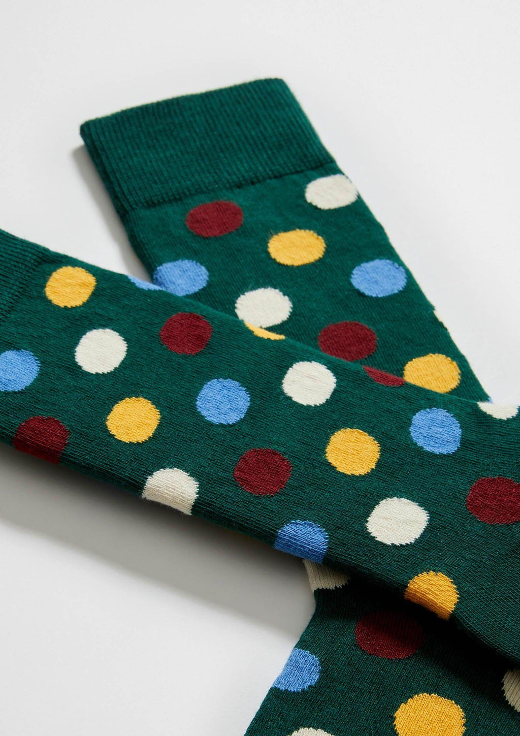 Calcetines BePolkadots Multicolor en verde oscuro con puntos grandes en rojo, amarillo y azul. Altura media caña.