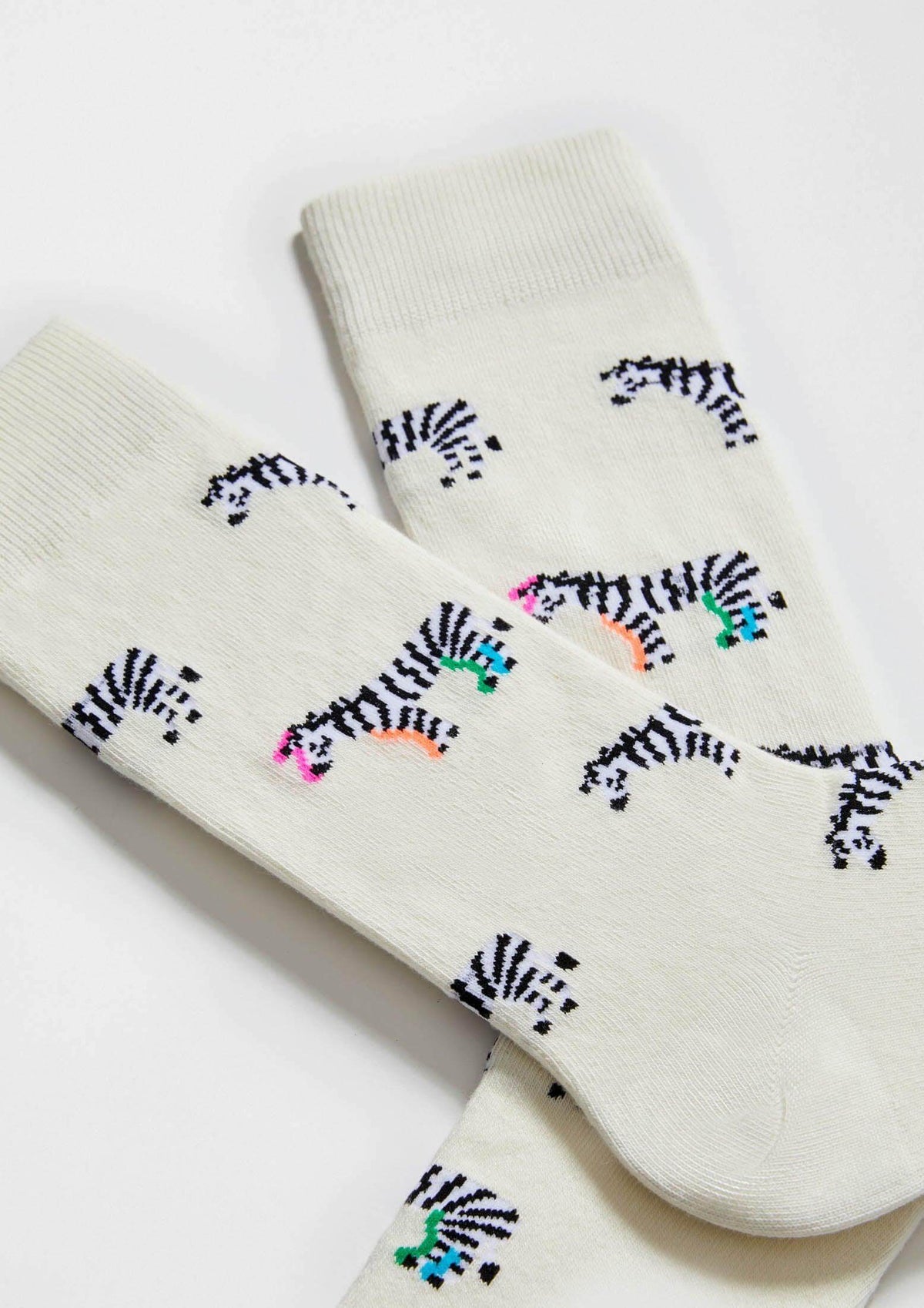 Calcetines BeZebra Beige de algodón orgánico con diseño de cebras en color crema y detalles en rosa y verde, altura media.