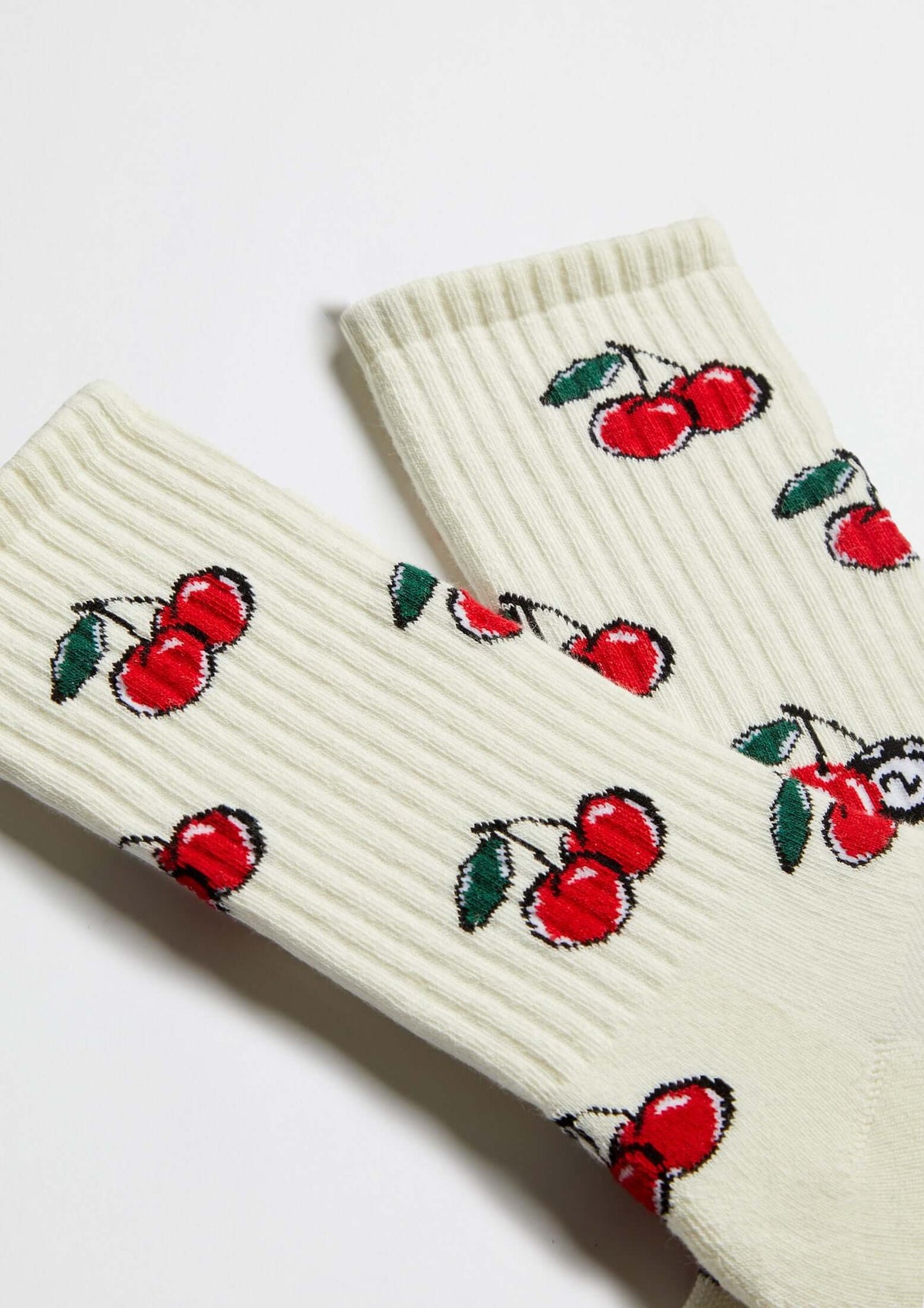 Calcetines BeCherry Beige de media caña en color crudo con estampado de cerezas rojas sobre fondo claro.