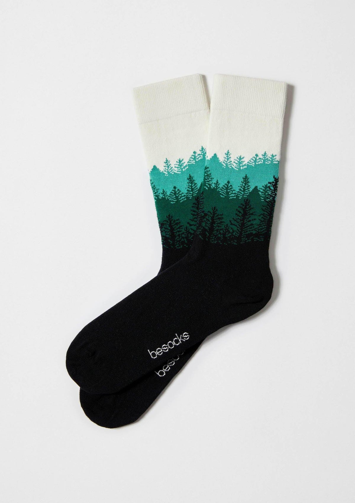 Calcetines BeForest con diseño de árboles en tonos verdes sobre base negra, altura media caña.
